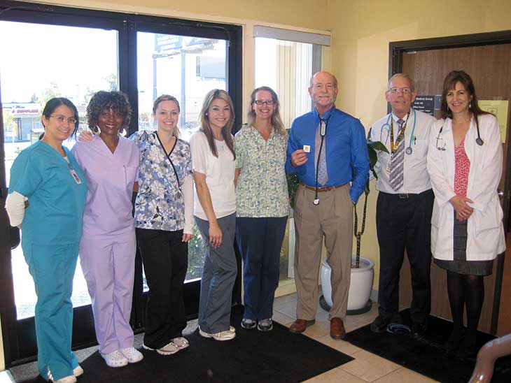 Dr. Jeffrey Dysart, Dr. Donald Tecca, and staff with gold Guardian Angel pin from Sharp Memorial Hospital